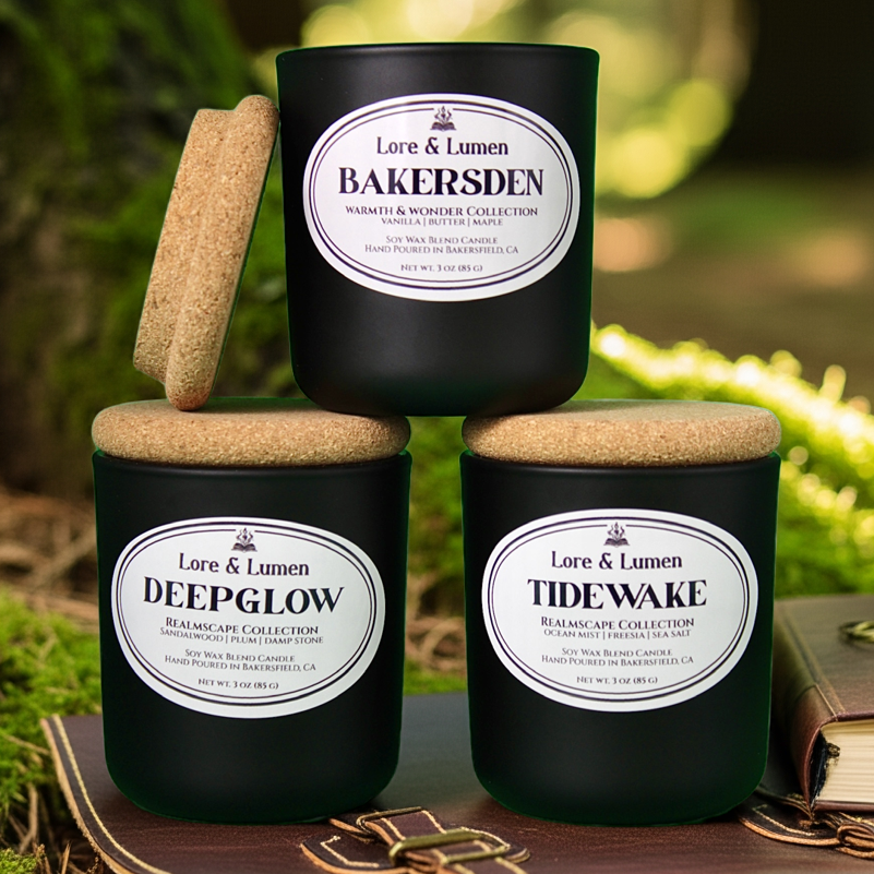 Three black candles with labels on a wooden surface outdoors